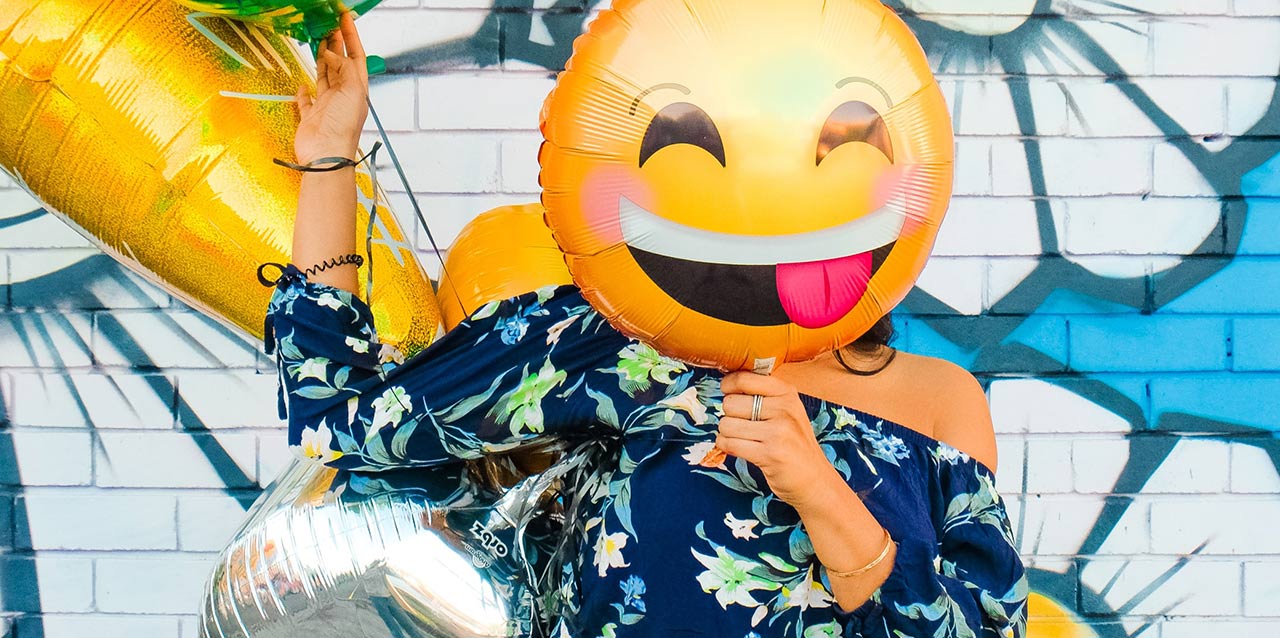 mulher a segurar balão de emoji