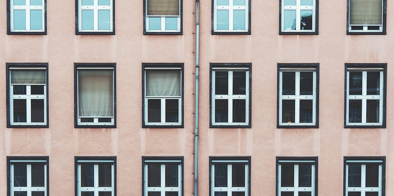 janelas iguais em edifício rosa